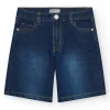 Bermuda en jean bleu moyen pour garçon avec surpiqûres contrastantes.