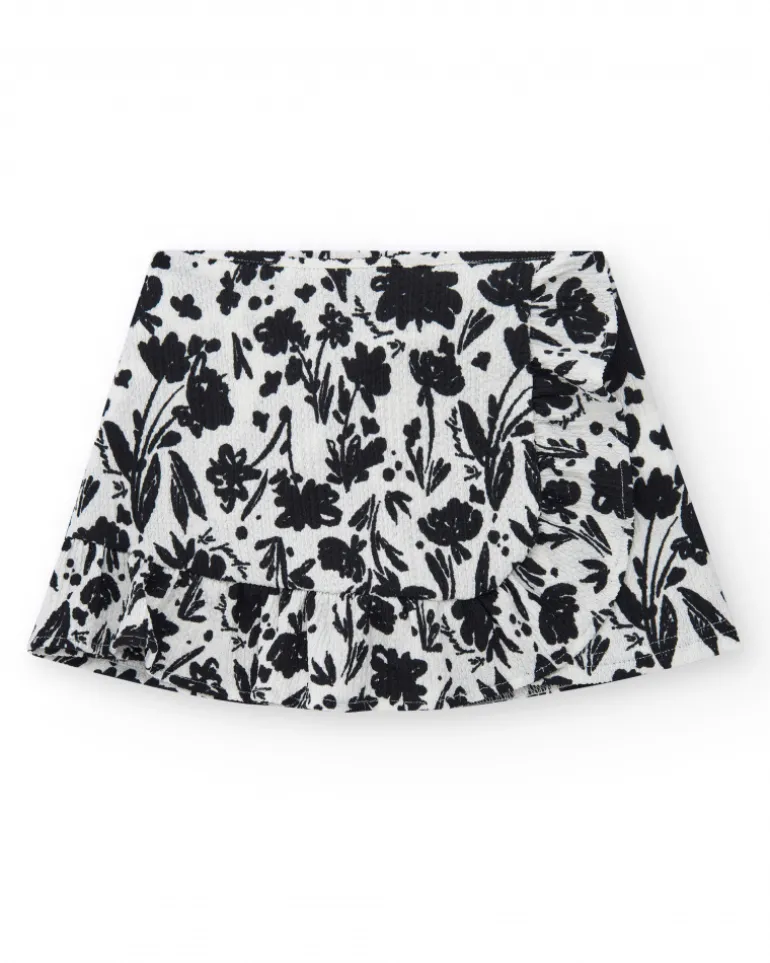 Jupe pour fille en blanc avec imprimé floral et volant.