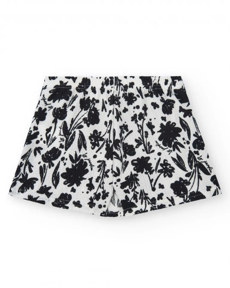 Jupe pour fille en blanc avec imprimé floral et volant.