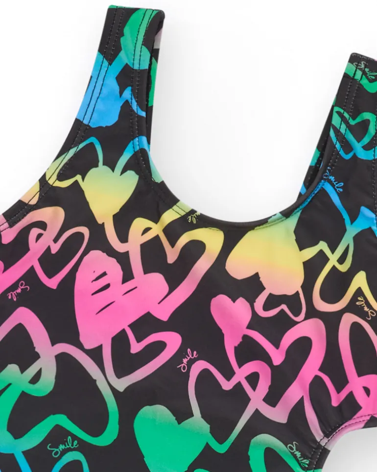 Maillot de bain pour fille en noir avec cœurs imprimés et ouverture latérale.