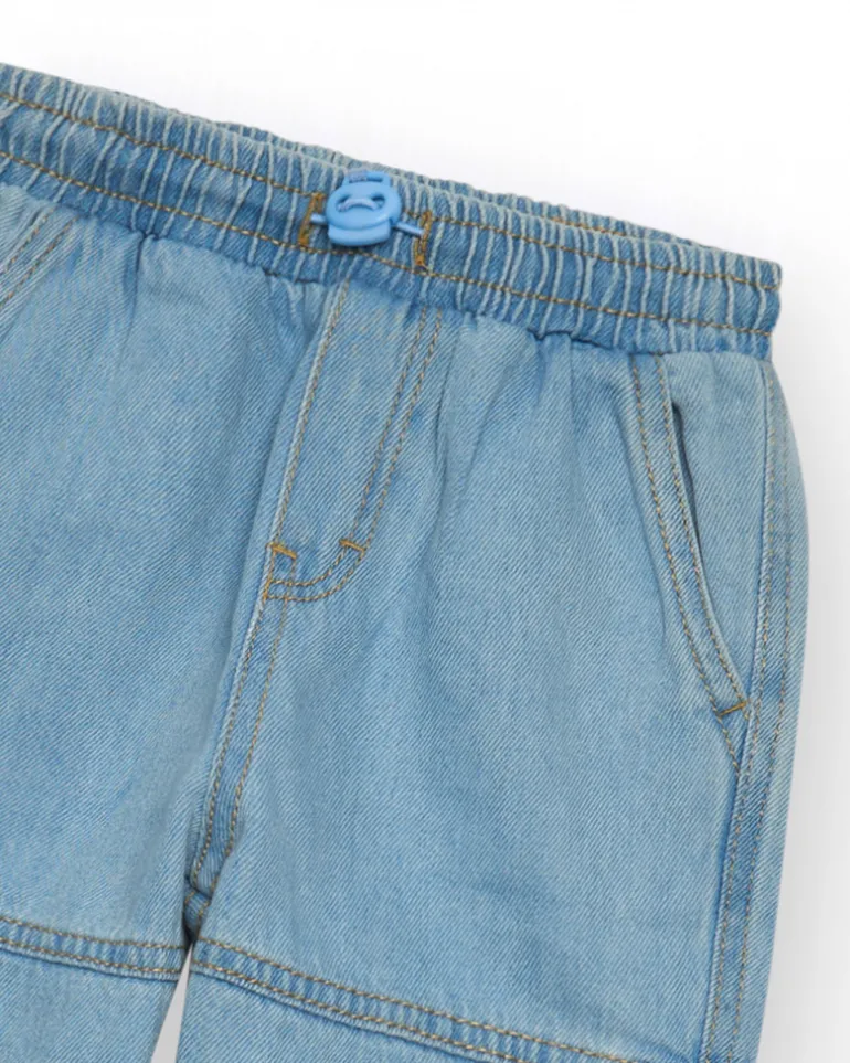 Pantalon cargo en denim clair pour garçon avec poches et ourlets ajustables.
