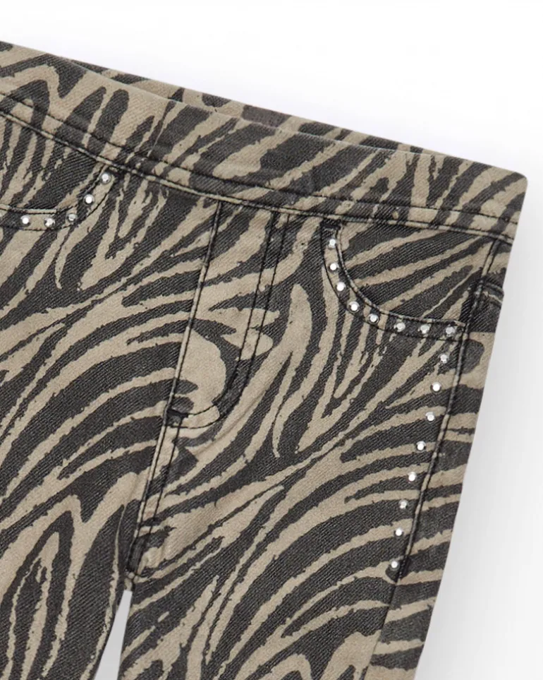 Pantalon pour fille en noir avec imprimé animal et clous à la taille.