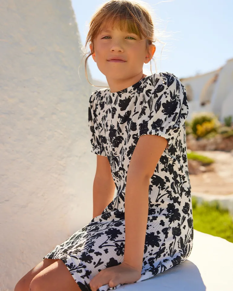 Robe pour fille en blanc et noir avec manches bouffantes et imprimé floral.