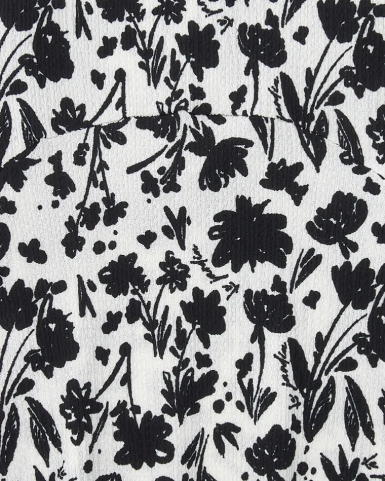 Robe pour fille en blanc et noir avec manches bouffantes et imprimé floral.