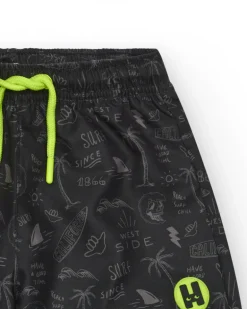 Short de bain noir pour garçon avec imprimé surfeur et cordon fluo.