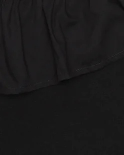 Top pour fille en noir avec design asymétrique et clous métalliques.